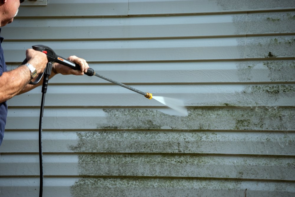 a man soft washing siding
